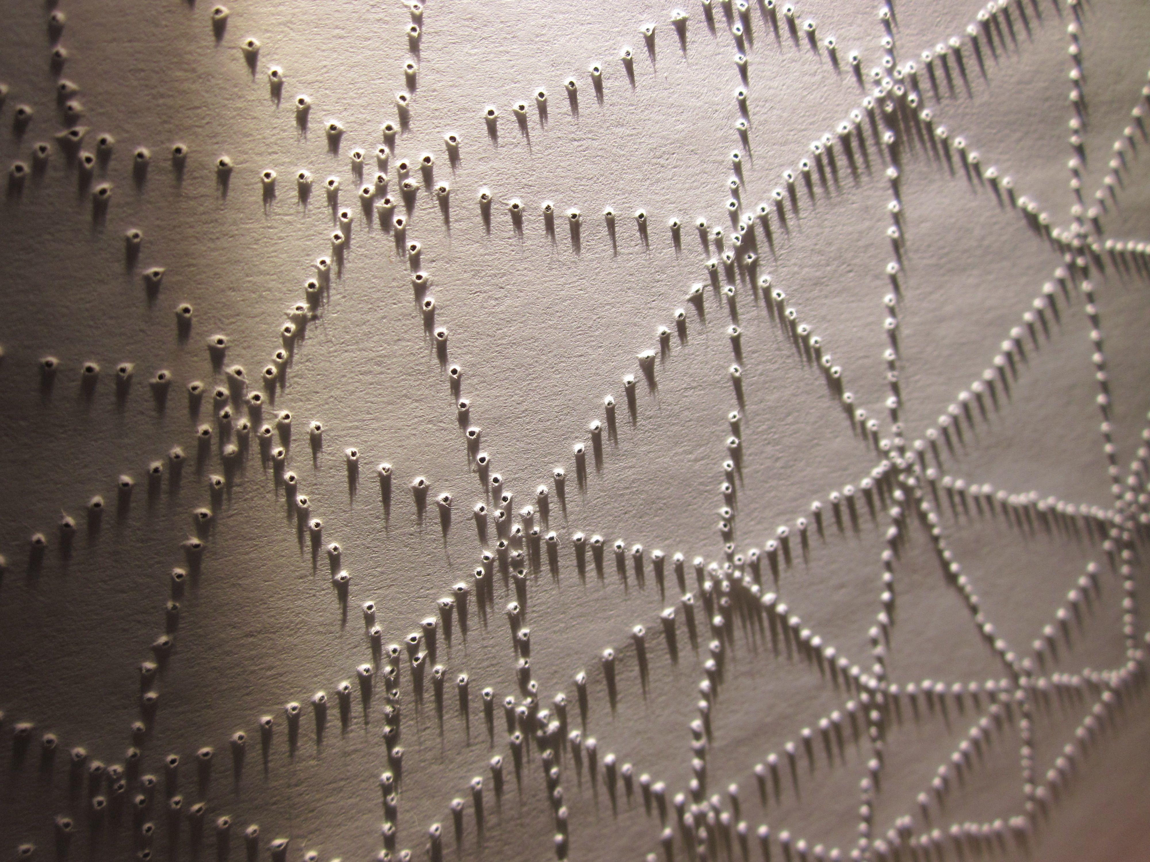 holes poked in paper in triangle pattern